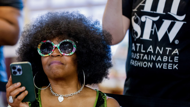 A woman watches as models presents their outfits during the Atlanta Sustainable Fashion Week show presented for World Environment Day in Atlanta, Georgia, USA, 03 June 2023